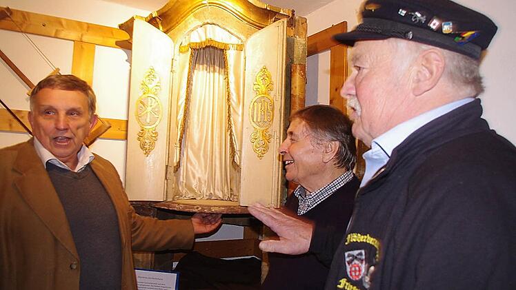 Pfarrarchivar Georg Schneider (l.), Franz Geiger (M.) und Georg Geiger vor dem Altarthron des Hochaltars. Dieser stammt wahrscheinlich aus dem Vorgängeraltar. Die beiden vergoldeten Flügeltüren verziert eine Blatt- und Weintraubenornamentik.