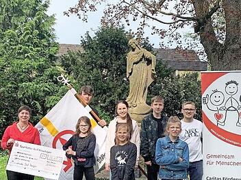 Die Ministranten sammelten 1615,50 Euro für ukrainische Flüchtlinge und übergaben während einer Gruppenstunde einen symbolischen Spendenscheck an die Caritas .