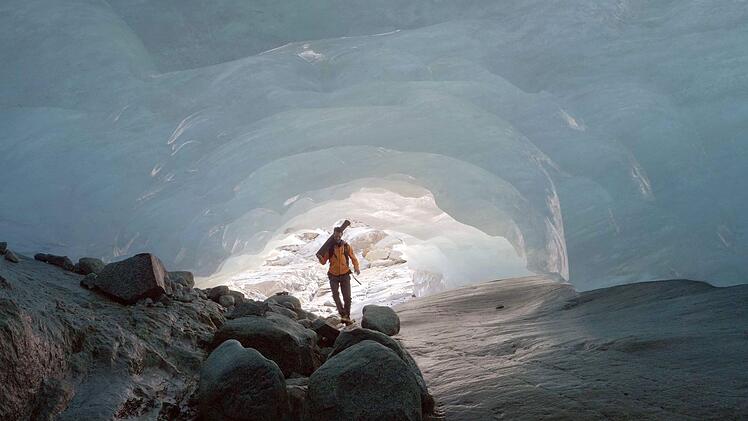 Der Schweizer Glaziologe Matthias Huss forscht in einer vom Schmelzwasser unter dem Rhonegletscher ausgeh&ouml;hlten Grotte. Das Schmelzwasser der Gletscher f&uuml;hrt zu unterirdischen Fl&uuml;ssen und Seen.