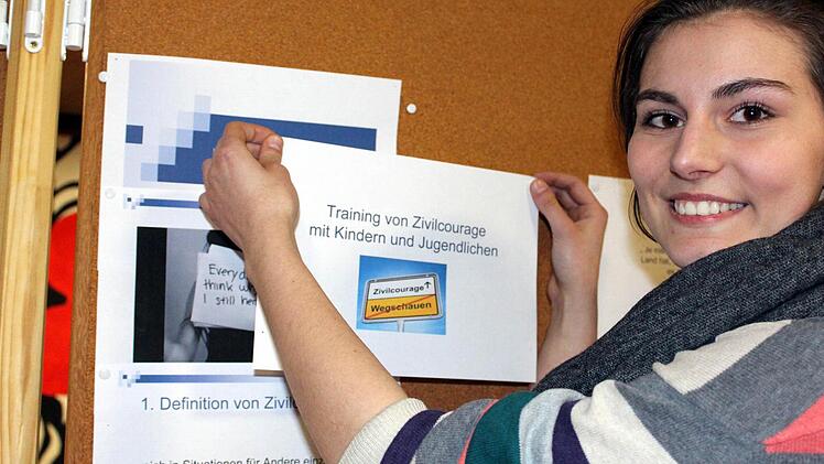 Mehr Zivilcourage wünschen sich Raffaela Rose und ihre Schulkameraden aus der 12. Klasse von ihren Mitmenschen. Die Ergebnisse ihrer Seminararbeiten haben sie in der Pausenhalle ausgehängt. Foto: Pfannes
