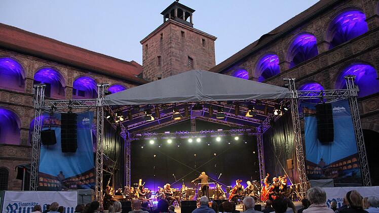 Vor der magisch illuminierten Plassenburg begeisterten die Hofer Symphoniker mit Gastdirigent Enrico Delamboye mit einem symphonischen Feuerwerk. Foto: Sonny Adam