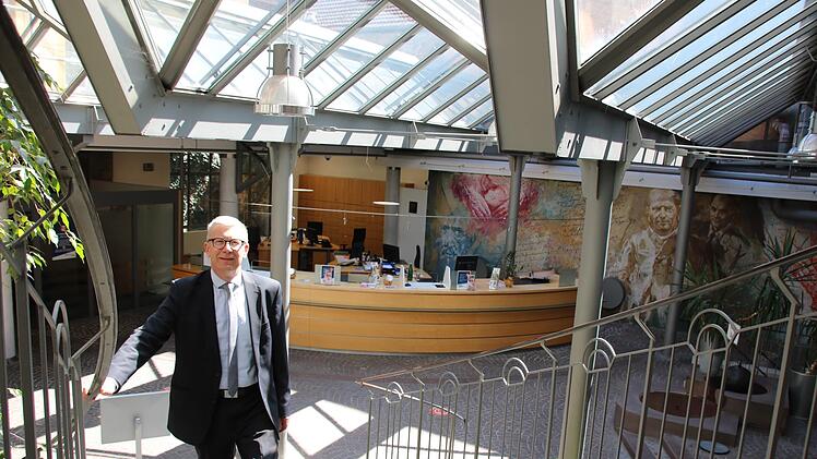 Vorstand Jürgen Klubertanz im Schalterraum der Raiffeisenbank: Das Glasdach wird erneuert, weil es undicht ist, die historische Bausubstanz und insbesondere das Höfling-Gemälde an der Rückwand bleiben aber erhalten.  Foto: Ralf Ruppert