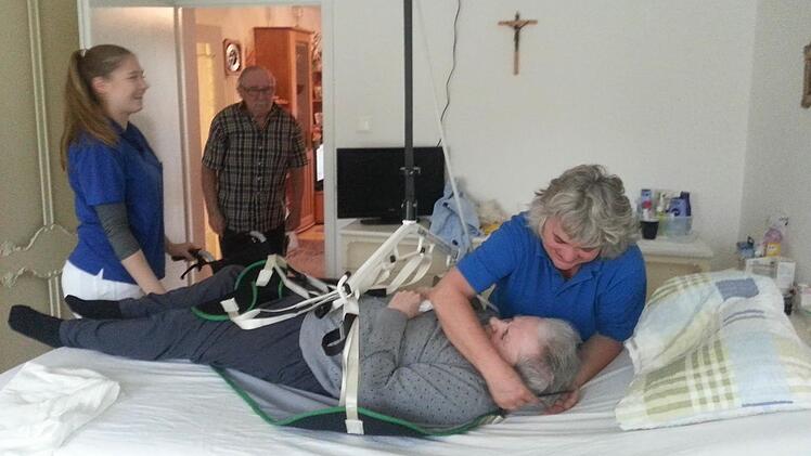 Brigitte Schuhmann-Müller bereitet alles vor, damit Else Dinnies mit Hilfe des Deckenlifts in den Rollstuhl gehoben werden kann. Links im Bild Julia Geppert, die im Rahmen ihres dualen Studiums zwei Monate Erfahrungen in der ambulanten Pflege sammelt.  Fotos: Sabine Christofzik