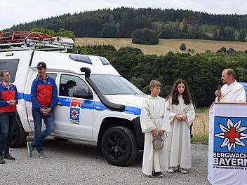 Diakon Frank Rüttiger segnet das neugestaltete Bergwachtgebäude.  Ganz links im Bild:  Bereichsleiter Johannes Voll und 2. Stellvertreter Pierre Martin (daneben). Foto: Regina Jopp