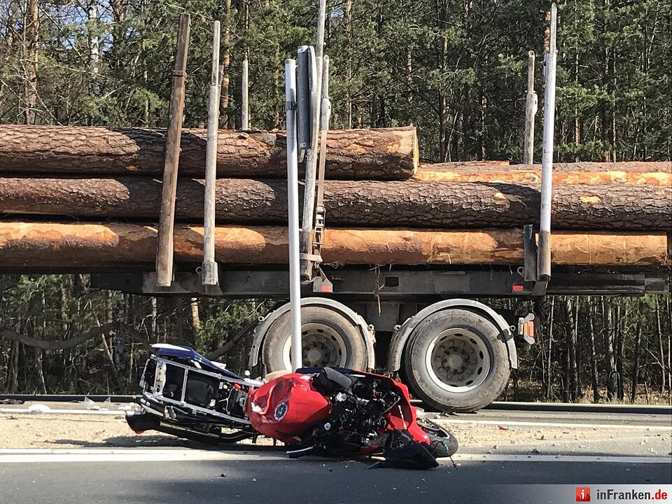 Motorradfahrer rutscht unter Lastwagen