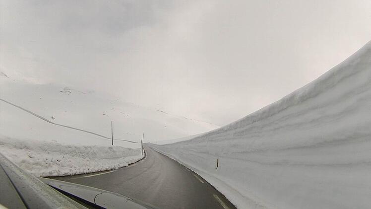 Unterwegs im Gebirge Jotunheimen - meterhohe Schneewände säumen die Straßen.