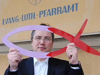 Pfarrer Wilde mit dem Zeichen der Kirchenvorstandswahl.