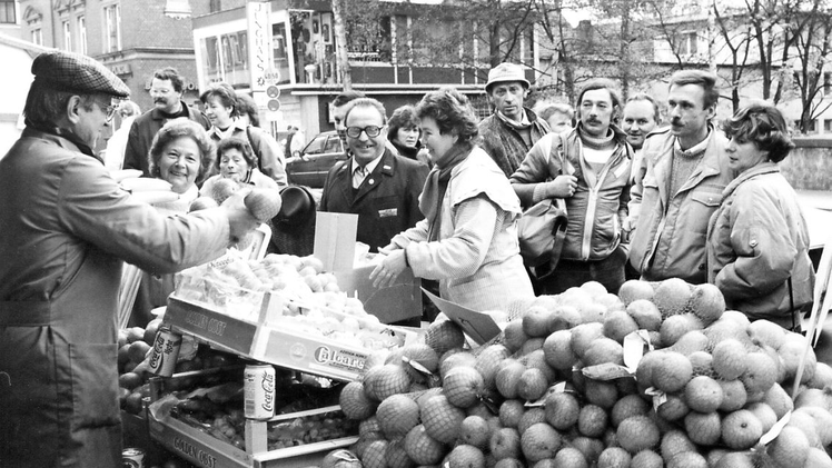 November 1989, Tage nach der Grenzöffnung in Coburg: Der Brücken-Adolf verschenkt Obst an die Besucher aus Ostdeutschland.  Foto: CT-Archiv