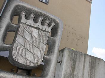 Direkt vor dem Kurgastzentrum, das im Herbst abgerissen werden soll, weist ein Wappen auf den Eigentümer Freistaat Bayern hin. Die Sorgfalt im Umgang mit der Vermarktung lässt aber zu wünschen übrig. Fotos: Ralf Ruppert