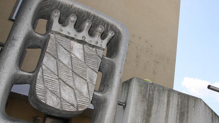 Direkt vor dem Kurgastzentrum, das im Herbst abgerissen werden soll, weist ein Wappen auf den Eigentümer Freistaat Bayern hin. Die Sorgfalt im Umgang mit der Vermarktung lässt aber zu wünschen übrig. Fotos: Ralf Ruppert