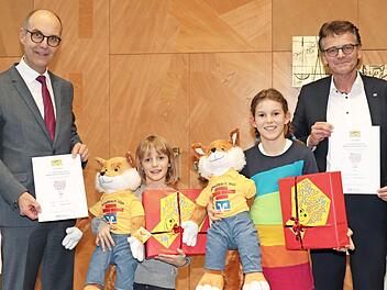 Regierungsvizepräsident Jochen Lange (links) zeichnet gemeinsam mit dem Vorstandsvorsitzenden der Raiffeisenbank Höchberg eG, Norbert Dorbath, die beiden Preisträger aus: Robin Hanselmann (Aschaffenburg) und Lucie Emmerth.  Foto: Hardenacke/Regierung von Unterfranken