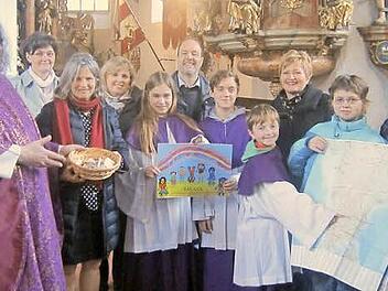 Die Pfarrei Glosberg übergibt die Kollekte des Gottesdienstes und zusätzlich eine Spende über 1000 Euro von den Pfarreimitgliedern an das Kinderhilfswerk SAC- CCC zur Unterstützung der armen Kinder in Indien. Mit im Bild Pater Waldemar Brysch (links), stellvertretende Pfarrgemeinderatsvorsitzende Annette Urban (Zweite von links), Pfarrgemeinderatsvorsitzende Sibylle Horn (Zweite von rechts) mit weiteren Pfarrgemeinderäten, Ministranten und dem Ehepaar Eiberger vom Kinderhilfswerk.  Foto: Hofmann