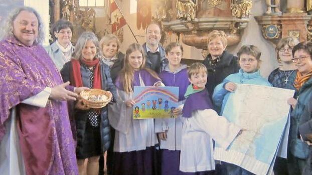 Die Pfarrei Glosberg übergibt die Kollekte des Gottesdienstes und zusätzlich eine Spende über 1000 Euro von den Pfarreimitgliedern an das Kinderhilfswerk SAC- CCC zur Unterstützung der armen Kinder in Indien. Mit im Bild Pater Waldemar Brysch (links), stellvertretende Pfarrgemeinderatsvorsitzende Annette Urban (Zweite von links), Pfarrgemeinderatsvorsitzende Sibylle Horn (Zweite von rechts) mit weiteren Pfarrgemeinderäten, Ministranten und dem Ehepaar Eiberger vom Kinderhilfswerk.  Foto: Hofmann