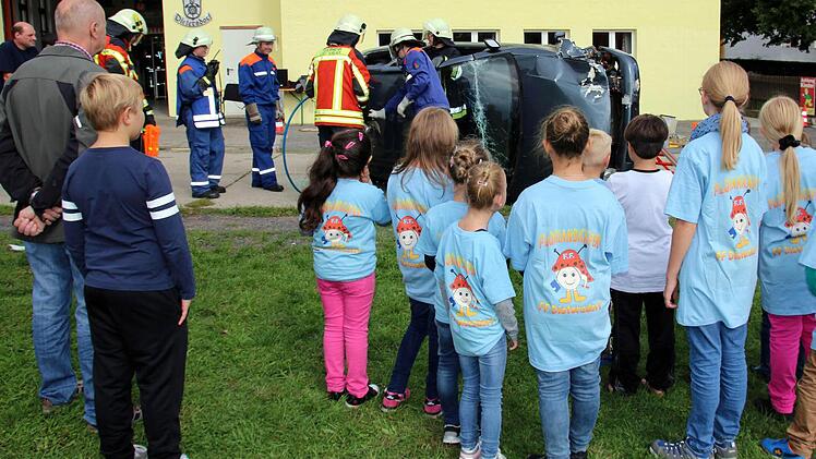 Ausgerüstet mit den neuen "Florianskäfer"-T-Shirts informierten sich die Interessenten für die erste Seßlacher Kinderfeuerwehr am Samstag in Dietersdorf, welchen Aufgaben sie sich als Feuerwehrleute werden stellen müssen. KBM Johannes Kempinski (rechts) erläuterte ihnen die einzelnen Schritte zur Rettung eines Verletzten aus einem Unfallfahrzeug. Foto: Bettina Knauth