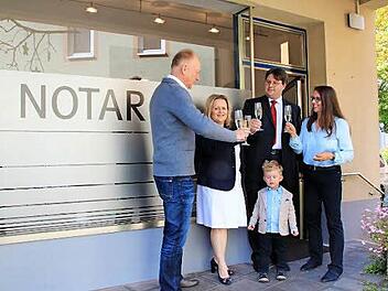 Bürgermeister Helmut Blank, Sandra Roßmann, Notar Markus Roßmann und Vermieterin Irmgard Reiter stoßen auf die neue Außenstelle des Münnerstädter Notariats an. Der kleine Maximilian Roßmann ist auch schon dabei. Foto: Heike Beudert