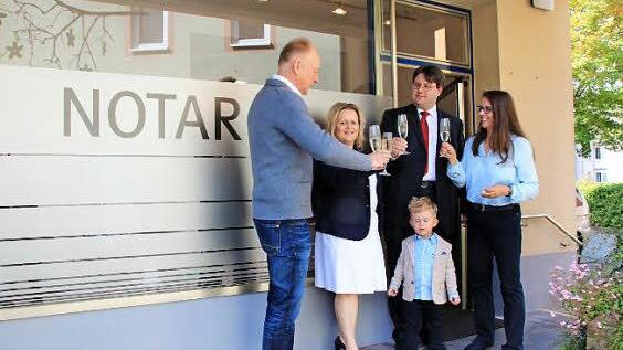 Bürgermeister Helmut Blank, Sandra Roßmann, Notar Markus Roßmann und Vermieterin Irmgard Reiter stoßen auf die neue Außenstelle des Münnerstädter Notariats an. Der kleine Maximilian Roßmann ist auch schon dabei. Foto: Heike Beudert