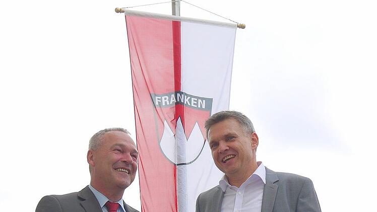 Schauen unter Frankens Flagge optimistisch in eine gemeinsame Zukunft: Neustadts Oberbürgermeister Frank Rebhan (SPD, links) und Sonnbergs Bürgermeister Heiko Voigt (parteilos). Foto: Berthold Köhler