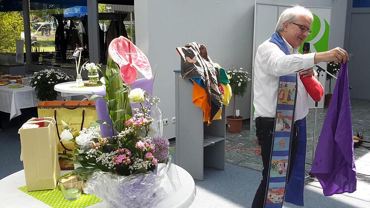 Das gesprochene Wort bereicherte Pfarrer Gerd Kirchner mit dem Einsatz symbolträchtiger Gegenstände. Jedes bunte Tuch hatte seine eigene Bedeutung. Foto: Rolf Pralle