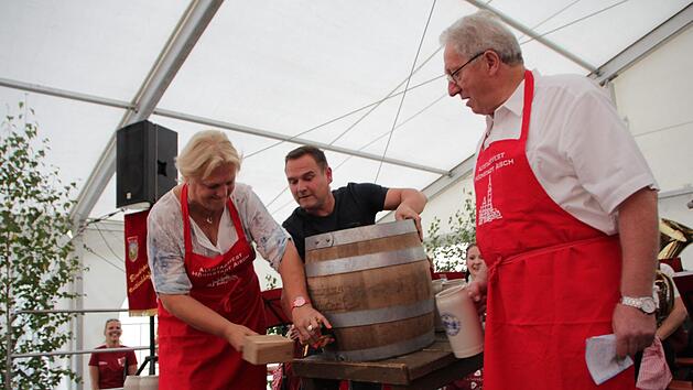 Gar nicht so einfach, dachte sich Irene H&auml;usler und holte  sich beim Anzapfen Unterst&uuml;tzung von Festwirt Michael Ackermann.  G&uuml;nter Schulz (rechts)  wollte diese Aufgabe mal einer Frau &uuml;berlassen.  Foto: Andreas Dorsch