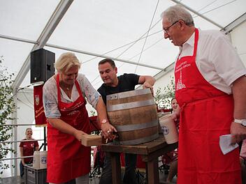 Gar nicht so einfach, dachte sich Irene Häusler und holte  sich beim Anzapfen Unterstützung von Festwirt Michael Ackermann.  Günter Schulz (rechts)  wollte diese Aufgabe mal einer Frau überlassen.  Foto: Andreas Dorsch