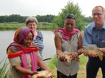 Martin Oberle (M.) macht Suzanne (l.) und Veronique mit dem fränkischen Karpfen bekannt. Foto: Lengenfelder