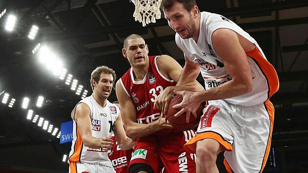 Im Hinspiel packt Maik Zirbes (Mitte) kr&auml;ftig zu und stoppt den Ulmer Matt Howard in letzter Sekunde. Links der Ulmer Scharfsch&uuml;tze Adam Hess. Foto: Daniel L&ouml;b