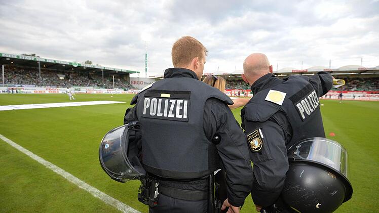 Polizisten stehen vor dem Spiel auf dem Rasen. Foto: Timm Schamberger/dpa