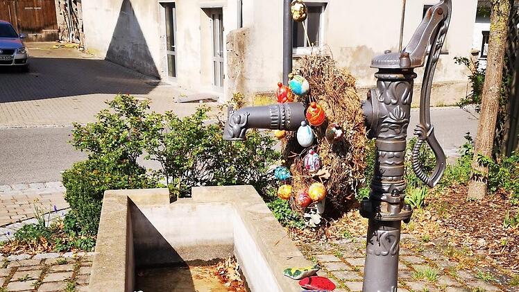 Statt des üblichen Osterbrunnenschmucks wird der "Hutzelbrunnen" in Fatschenbrunn in diesem Jahr von bunten Steinen geziert, die die Kinder des Dorfes gestalteten und dann am Brunnen ablegten.  Fotos: sw