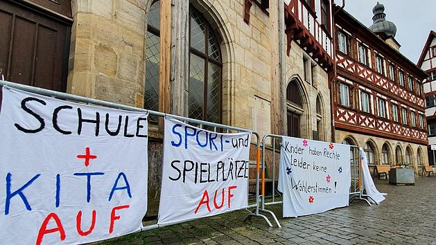 Am Donnerstagmorgen wurden vier bemalte Bettlaken &uuml;ber die Bauz&auml;une vor dem Rathaus geh&auml;ngt. Foto: Ronald Heck