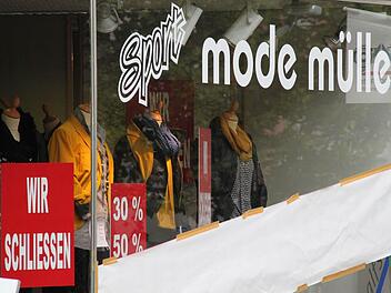 Ein Plakat kündigt an, dass Mode Müller schließt. Foto: Heike Beudert