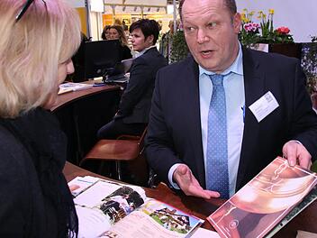 Alexander Höfling (Staatsbad Bad Bocklet) mit einer Messebesucherin auf dem Stand des Bayerischen Heilbäderverbandes auf der Messe Caravan-Motor-Tourismus (CMT) in Stuttgart. Foto: Paul Ziegler