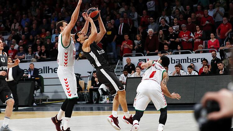 Nikos Zisis von Brose Bamberg will unter dem Korb abschließen, aber der Wahl-Spanier Johannes Voigtmann (l.) lauert schon auf den Block; rechts Shane Larkin. Fotos: Daniel Löb