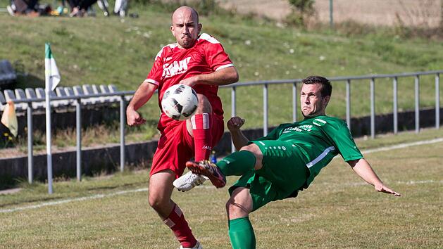 Mit vollem Einsatz gehen der Stockheimer Philipp Fischer (gr&uuml;nes Trikot) und sein Ludwigsstadter Gegenspieler Felix Kraus zum Ball.  Foto: Heinrich Wei&szlig;