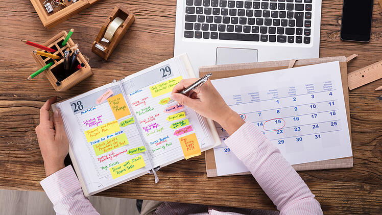 Businesswoman Writing Schedule In Calendar Diary