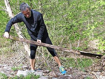Hubert Karl zeigt, was übrig ist vom Zeiler Trimm-Dich-Pfad: Das halb verrottete Schild, das die Station 15 (Fuß-Erlebnis-Pfad) beschreibt, hat er aus dem Gestrüpp hervorgezogen. Aber gelogen ist es ja nicht, was da drauf steht: Es ist immer noch ein Fuß-Erlebnis, wenn man über die Reste der Station hinweg läuft. Fotos: Andreas Lösch