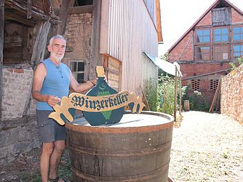 Karl-Heinz Maul ist einer von rund zehn Hammelburger Winzern, die ihre Trauben noch bei der GWF abliefern. Vom geschlossenen Winzerkeller hat er das Schild und den zum Tisch umfunktionierten Holz-Bottich gerettet.