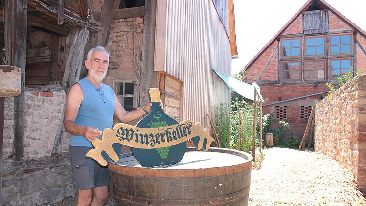 Karl-Heinz Maul ist einer von rund zehn Hammelburger Winzern, die ihre Trauben noch bei der GWF abliefern. Vom geschlossenen Winzerkeller hat er das Schild und den zum Tisch umfunktionierten Holz-Bottich gerettet.