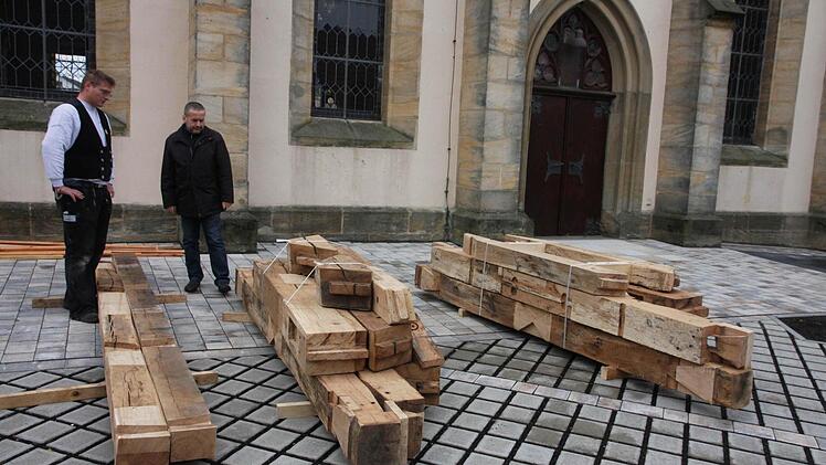 Pfarrer Beißer (r.) und David Lauer inspizieren die renovierten Teile des Glockenstuhls.