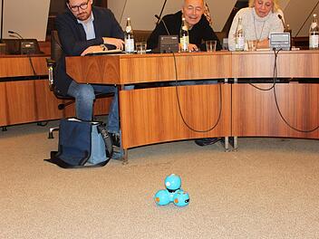 Dash, der Spielzeug-Roboter, sorgt bei den Stadträten für neugierige Blicke; von links Ralf Schneider, Günter Reinlein und Monika Faber aus der SPD-Fraktion bei einer Sitzung des Ausschusses für Stadtentwicklung, in der neue Medien der Stadtbücherei vorgestellt wurden. Popp