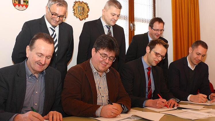 Die Bürgermeister (sitzend, von links) Ludwig Göhl (Stadelhofen), Udo Dauer (Weismain), Andreas Pöhner (Wonsees) und Martin Bernreuther (Thurnau) mit (stehend, von links) Reinhard Brandl und Friedrich Weinlein von der Telekom sowie Siegbert Reuther bei der Unterzeichnung der Kooperationsverträge. Foto: Stefan Lutter