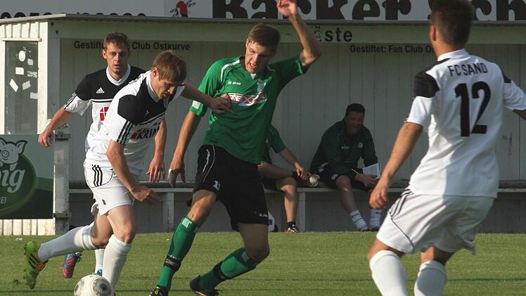 Der Sander Stefan Krines (Zweiter von links) versucht sich seinen Gegner vom Leib und Ball zu halten. Links Dominik Rippstein und rechts Lucas Wirth.