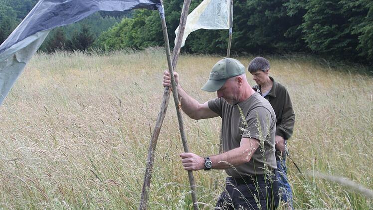 Oliver und Katrin Höfner stecken Fahnen in eine Wiese, die am nächsten Tag gemäht werden soll. Reh-Mütter stufen das flatternde Plastik als Gefahr ein. Sie bringen ihre Kitze in Sicherheit.  Foto: Schadeck