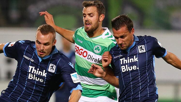 Auf dem Platz wird Stefan Thesker (Mitte) von seinen Gegenspielern in die Mangel genommen. In der Nacht auf Sonntag ist der Profi der SpVgg Greuther Fürth von Türstehern aus einer Disko in Nürnberg geschmissen worden. Foto: Daniel Karmann/dpa