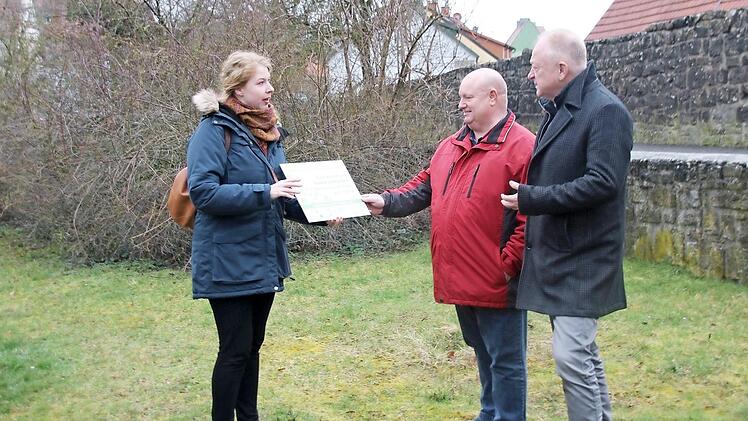 Jasmin Fidyka zeigt Umweltreferent Klaus Schebler und Bürgermeister Helmut Blank das Schild, das an den neuen Blühflächen angebracht wird. Eine solche wird beispielsweise am Parkplatz Oberes Tor entstehen.  Fotos: Thomas Malz