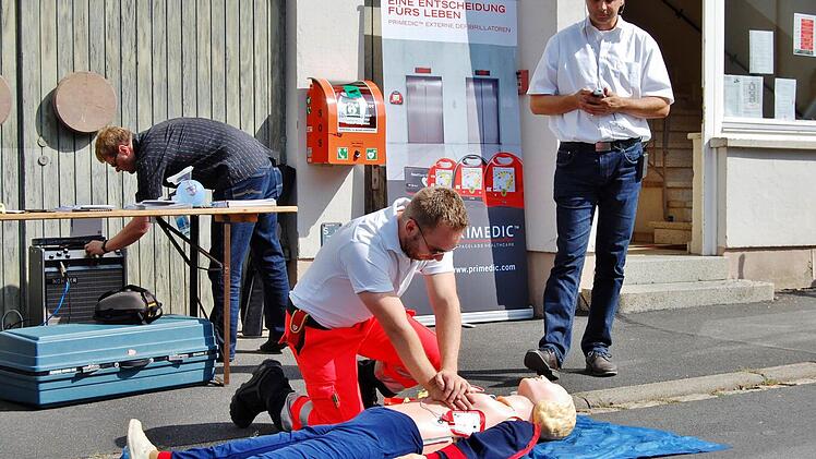 Projektmanager Thomas Schreiner (Zentrum für Telemedizin, Bad Kissingen) und BRK-Dozent Christian Bauer erklärten den Albertshäusern die Handhabung des Externen Automatisierten Defibrilators (AED). Foto: Sigismund von Dobschütz