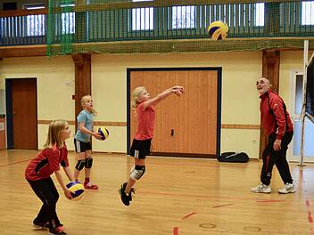 Volleyballtraining der U12 in der Aschacher Zehnthalle. Lara Enzmann bridscht den Ball über das Netz. Maria Martin (vorne) und Hanna Walkenhorst stehen schon parat, es Lara gleichzutun. Trainer Walter Kuhn beobachtet genau, was seine Mädels machen. Foto: Kathrin Kupka-Hahn