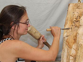 Katharina Mörth arbeitet vor dem Forstamt in Nordhalben an einem Lucas-Cranach-Projekt. Mit Hammer und Stemmeisen formt sie die Figuren.