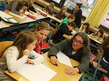 Zusammen mit Künstler Herman überlegen Julia (links) und Eva, was sie auf ihre T-Shirts malen wollen. Foto: Barbara Herbst