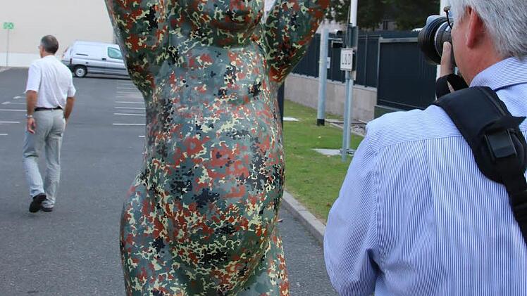 Der in Tarnfarben gestaltete Hauptstadt-Bär vor dem Bundesverteidigungsministerium dient als Foto-Motiv. Foto: Ralf Ruppert