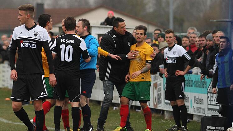 : Am Schluss kam auch noch etwas Hektik auf und neben dem Schiedsrichter beruhigt sogar der Sander Trainer Bernd Eigner den Bamberger Dominik Schütz (2, von rechts)